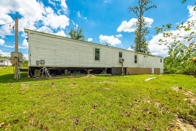 back of property featuring cooling unit and a lawn