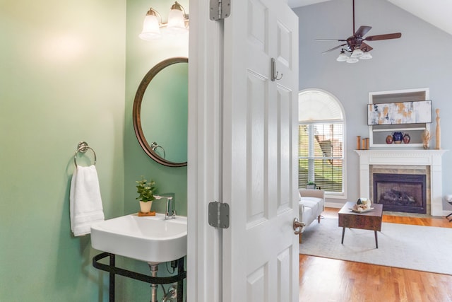 bathroom featuring wood-type flooring, a fireplace, high vaulted ceiling, and ceiling fan