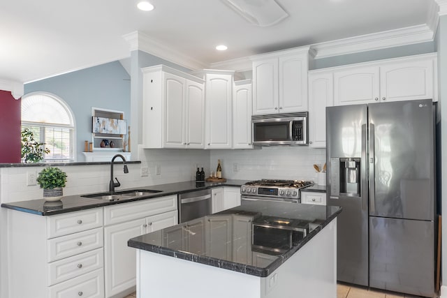 kitchen with sink, white cabinetry, a kitchen island, appliances with stainless steel finishes, and ornamental molding