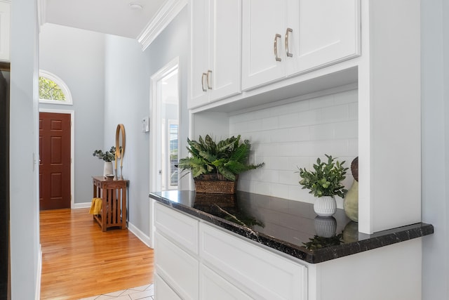 interior space featuring light hardwood / wood-style flooring, white cabinets, and crown molding