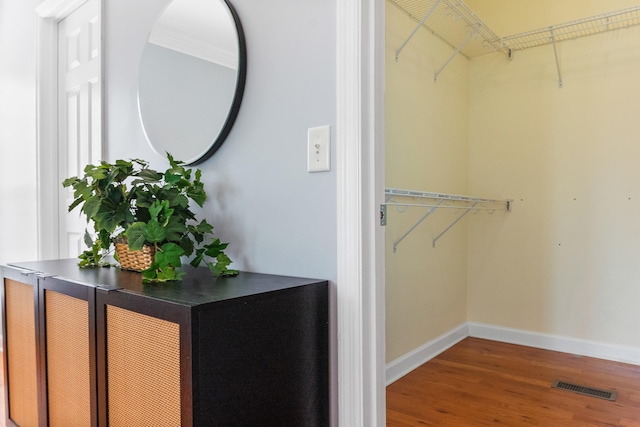 walk in closet with hardwood / wood-style floors