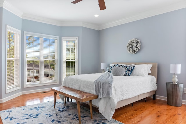 bedroom with light hardwood / wood-style flooring, ceiling fan, and crown molding