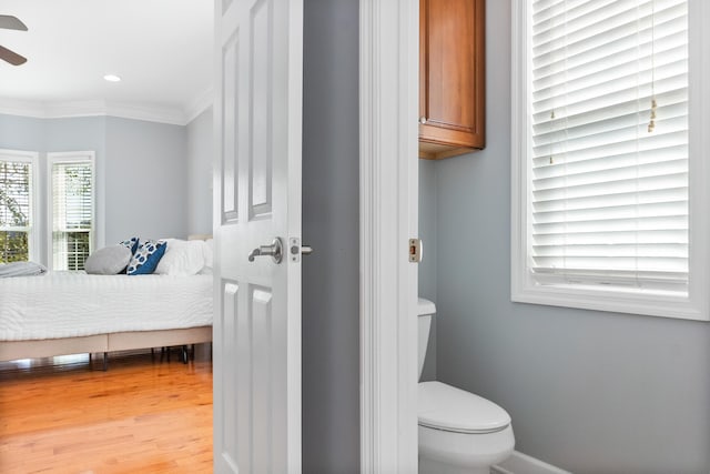 bathroom featuring hardwood / wood-style floors, ornamental molding, toilet, and ceiling fan