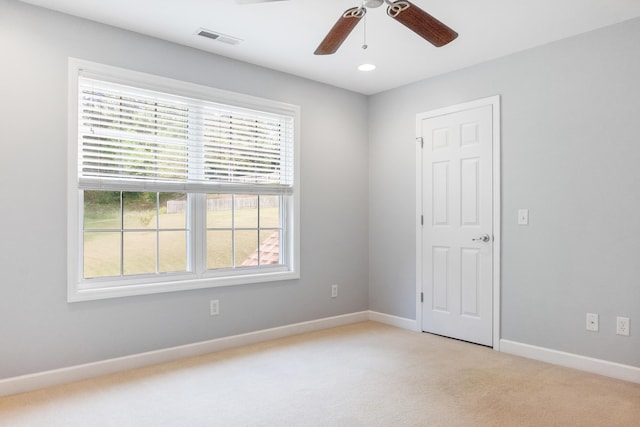 carpeted spare room with ceiling fan