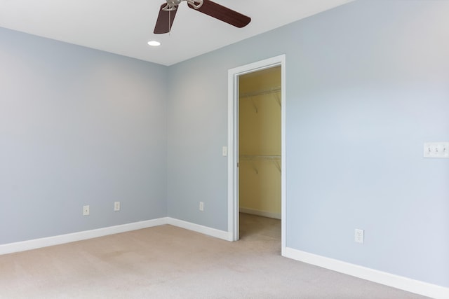 spare room with ceiling fan and light colored carpet