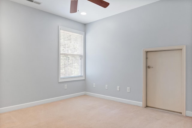 unfurnished room featuring ceiling fan, light colored carpet, and a healthy amount of sunlight