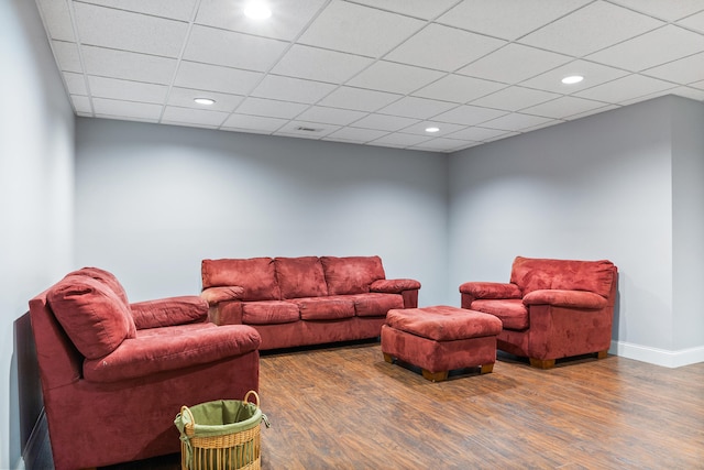 living room featuring wood-type flooring and a drop ceiling