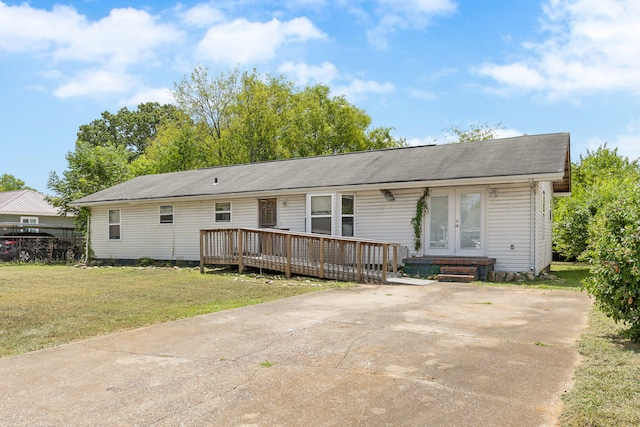 ranch-style house with a wooden deck and a front lawn