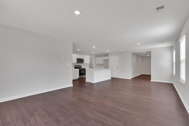 unfurnished living room with dark hardwood / wood-style flooring