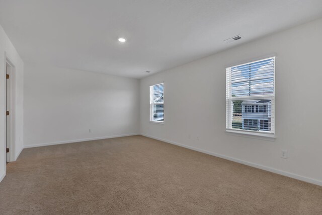 spare room featuring light colored carpet