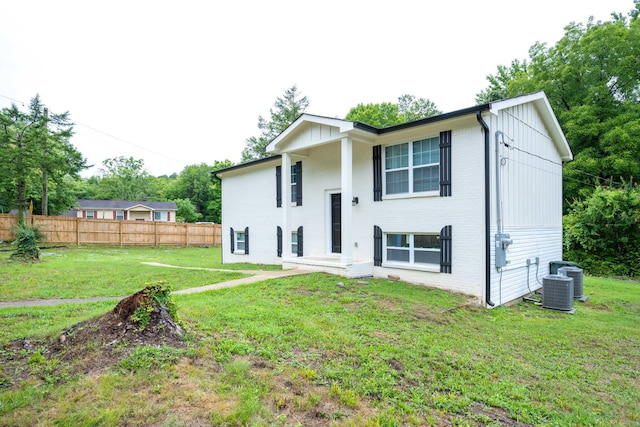 back of property with a lawn and central air condition unit