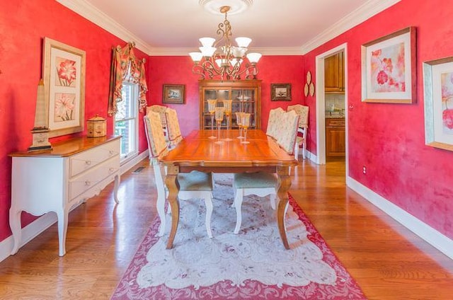 dining room with crown molding, hardwood / wood-style flooring, and a chandelier