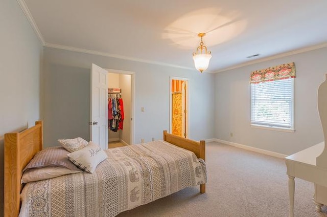 bedroom with a walk in closet, carpet, a closet, and crown molding