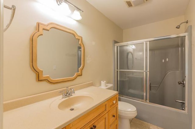 full bathroom featuring shower / bath combination with glass door, vanity, toilet, and tile patterned floors