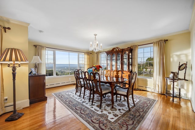 dining area with ornamental molding, a baseboard radiator, an inviting chandelier, and light wood-type flooring