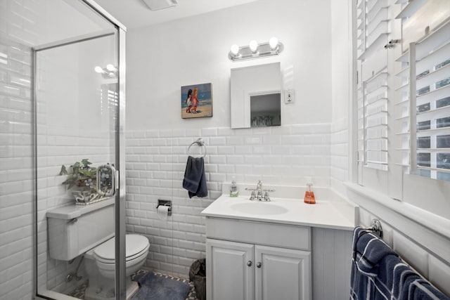 bathroom featuring vanity, toilet, and tile walls