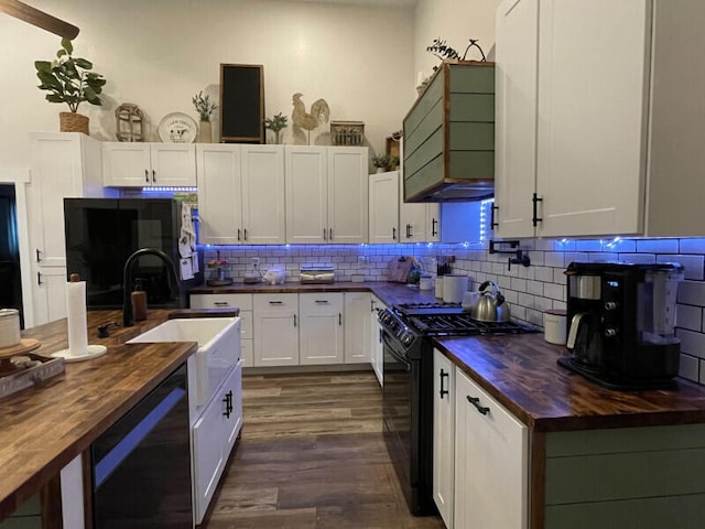 kitchen with white cabinets, black appliances, decorative backsplash, dark hardwood / wood-style floors, and butcher block countertops