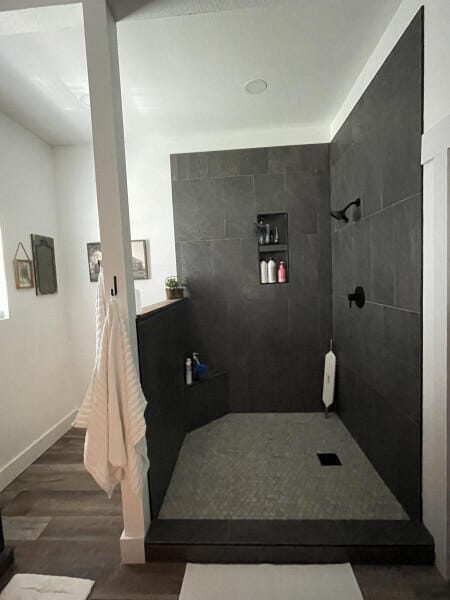 bathroom with wood-type flooring and tiled shower