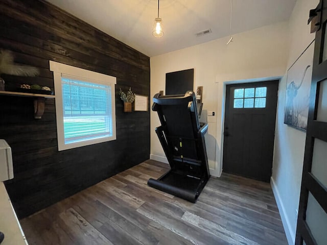 workout area featuring wooden walls and dark hardwood / wood-style flooring