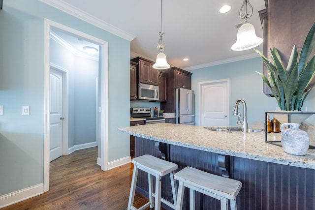 kitchen featuring a kitchen breakfast bar, dark hardwood / wood-style flooring, pendant lighting, stainless steel appliances, and sink