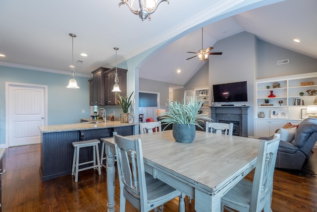 dining space featuring ceiling fan with notable chandelier, dark hardwood / wood-style floors, sink, and ornamental molding