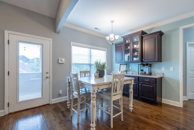 dining space with crown molding, dark hardwood / wood-style flooring, and a chandelier