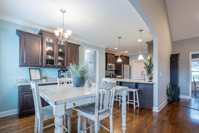 dining area featuring ornamental molding, dark hardwood / wood-style floors, and an inviting chandelier