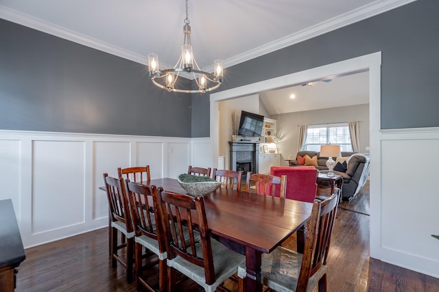 dining space with crown molding, dark wood-type flooring, lofted ceiling, and an inviting chandelier