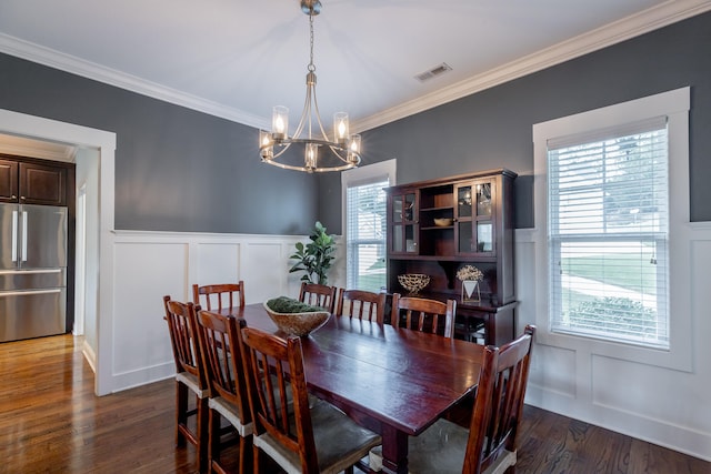 dining room with ornamental molding, plenty of natural light, dark hardwood / wood-style floors, and an inviting chandelier