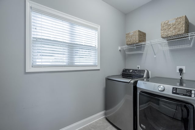 laundry room with light tile patterned floors and washing machine and clothes dryer