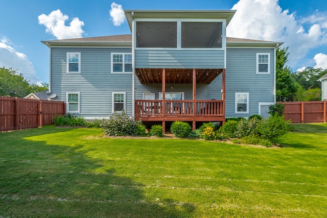 rear view of property featuring a lawn, a wooden deck, and a sunroom