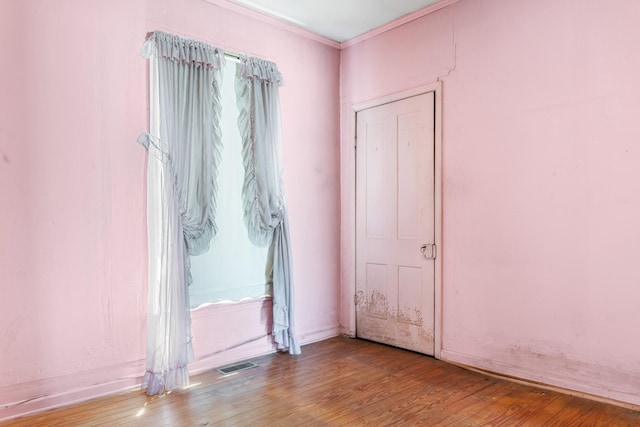 spare room featuring hardwood / wood-style flooring and crown molding