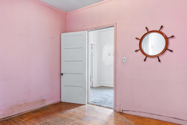 empty room with crown molding and hardwood / wood-style flooring