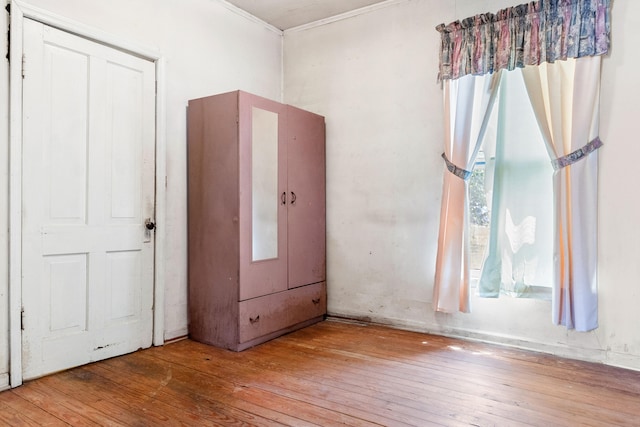 unfurnished bedroom with light wood-type flooring and crown molding