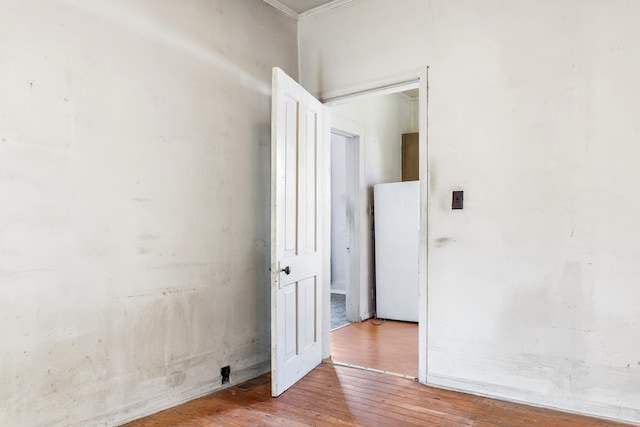 empty room featuring wood-type flooring and ornamental molding