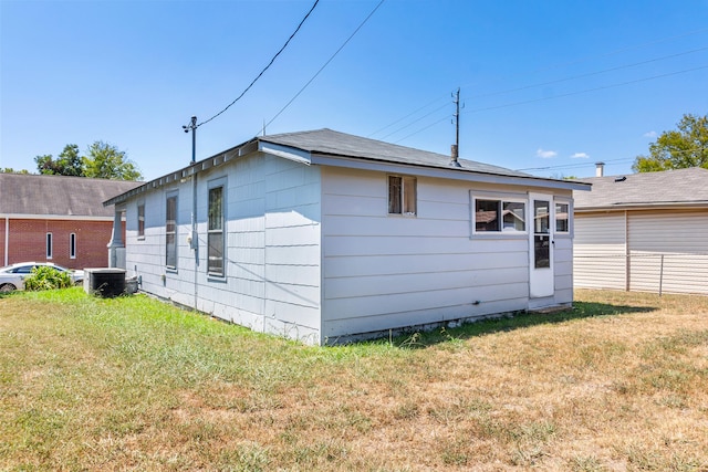 view of side of property with a lawn and central AC