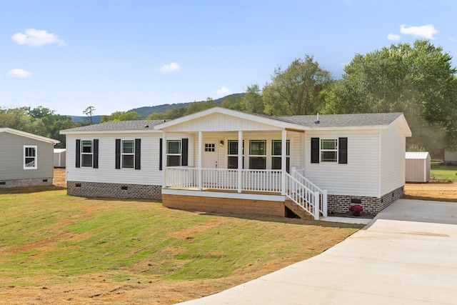 manufactured / mobile home featuring a porch and a front lawn