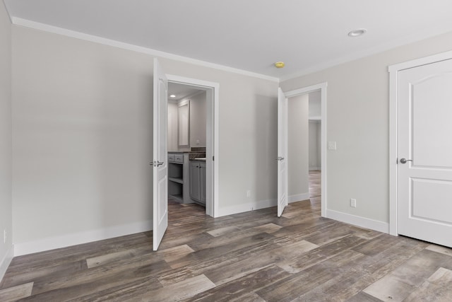 unfurnished bedroom featuring crown molding and dark hardwood / wood-style flooring