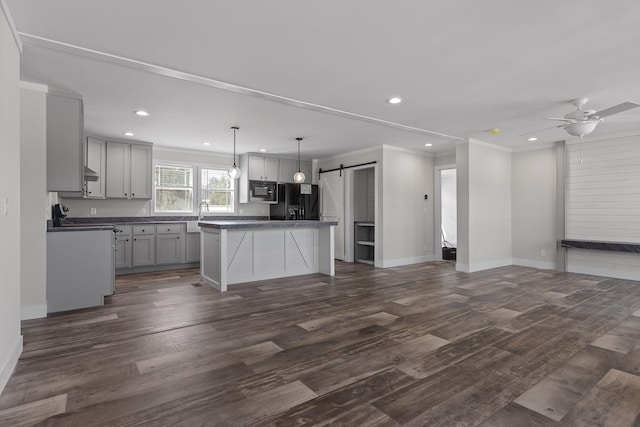 kitchen featuring a kitchen island, gray cabinetry, dark wood-type flooring, black refrigerator with ice dispenser, and a barn door