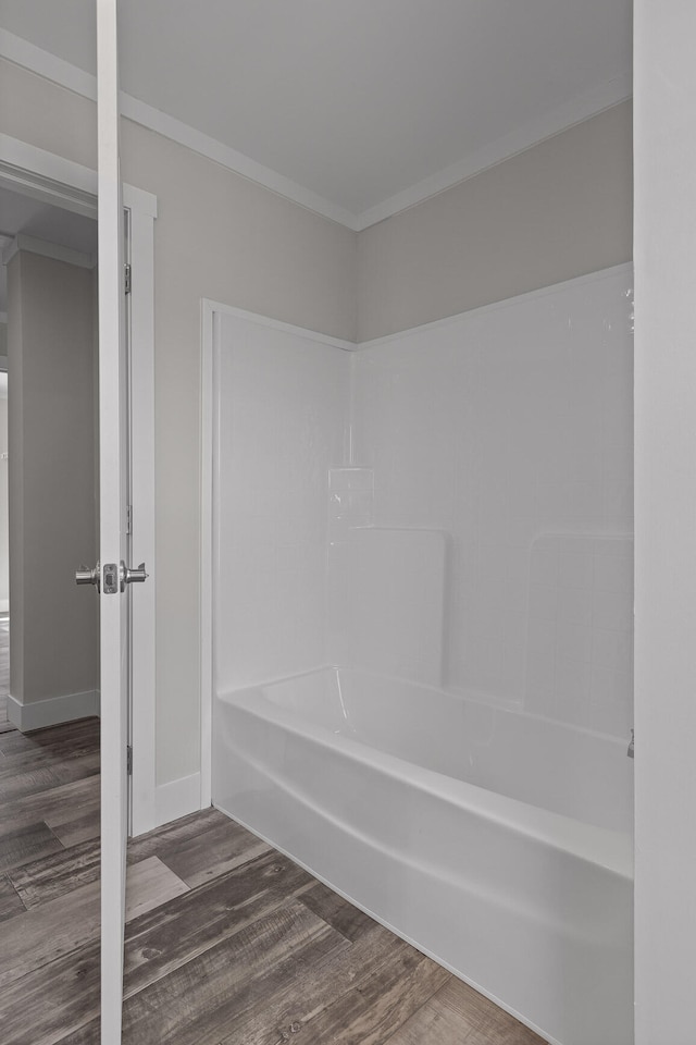 bathroom with shower / tub combination, hardwood / wood-style flooring, and ornamental molding