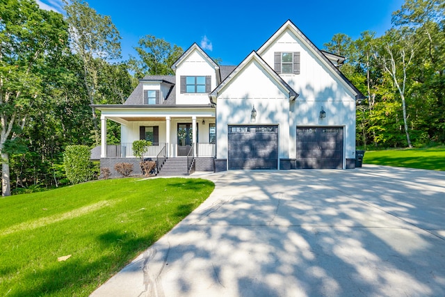 view of front facade featuring a porch, a garage, and a front yard