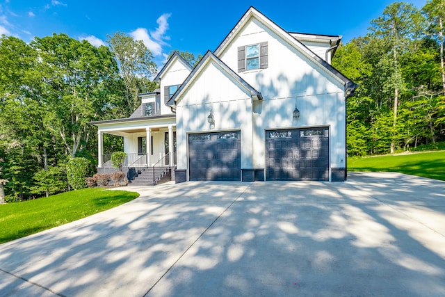 view of front of house with covered porch, a front yard, and a garage