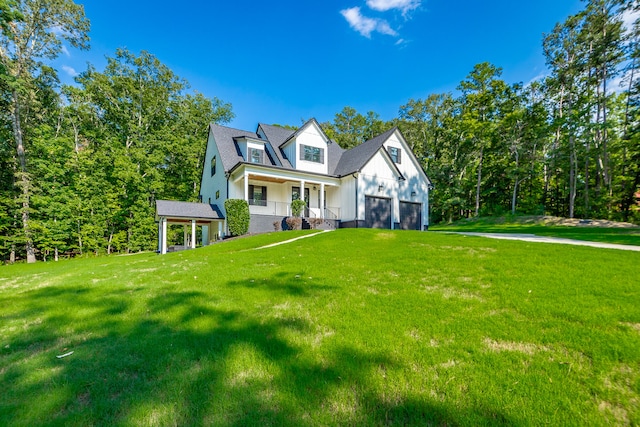 new england style home featuring a garage, a front lawn, and covered porch