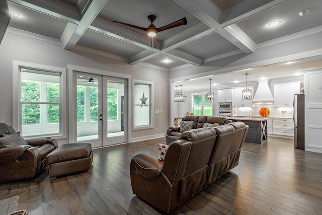 living room featuring ceiling fan with notable chandelier, french doors, hardwood / wood-style flooring, and beam ceiling