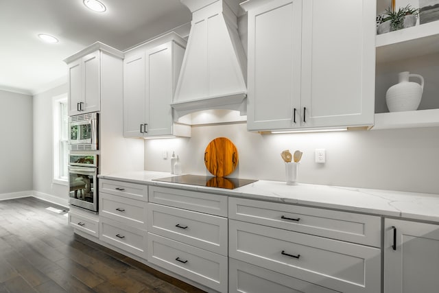 kitchen featuring light stone countertops, dark hardwood / wood-style flooring, custom range hood, stainless steel appliances, and white cabinets