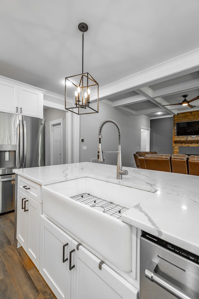 kitchen featuring ceiling fan with notable chandelier, appliances with stainless steel finishes, hanging light fixtures, dark wood-type flooring, and white cabinets