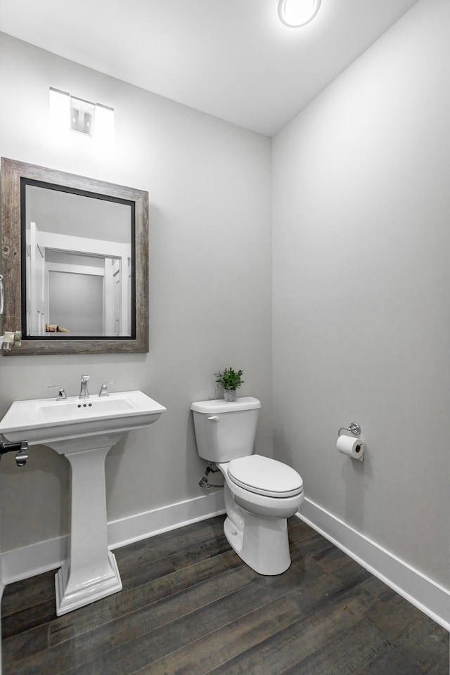 bathroom featuring toilet and wood-type flooring