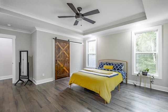 bedroom featuring a barn door, ceiling fan, multiple windows, and dark hardwood / wood-style flooring