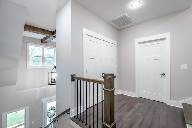 hall with dark wood-type flooring and beam ceiling