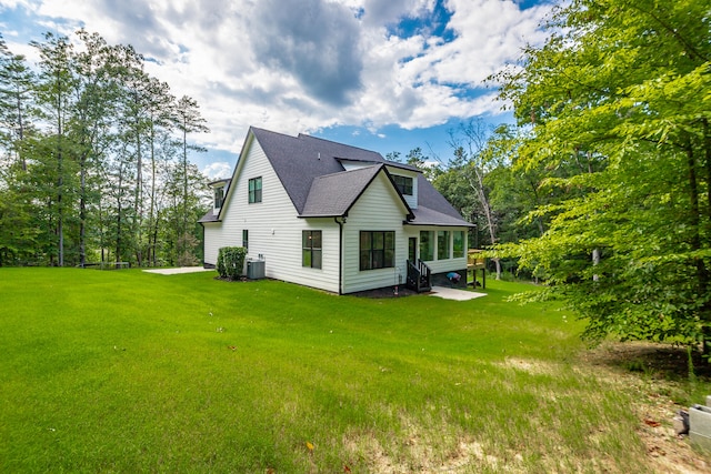 view of side of home featuring a lawn, a patio, and central AC unit